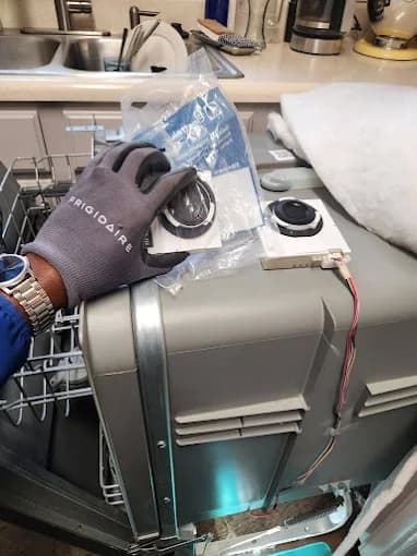 Technician installing a new pump in a dishwasher